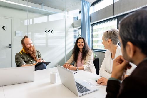 Vier Personen sitzen versammelt um einen Tisch