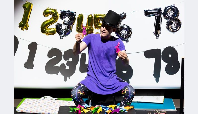 Andreas with hat in front of garland with numbers